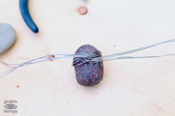 Making a spider from rocks and wire.