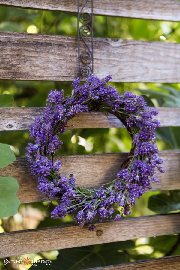 lavender wreath hanging on a wooden fence