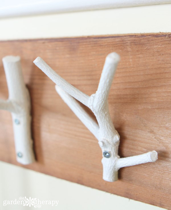 This inexpensive and easy weekend project shows you how to create a stylish branch coat rack with just some branches, paint, and a few tools.