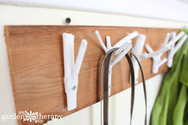 This inexpensive and easy weekend project shows you how to create a stylish branch coat rack with just some branches, paint, and a few tools.