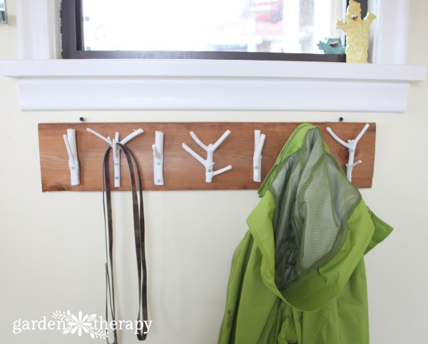 This inexpensive and easy weekend project shows you how to create a stylish branch coat rack with just some branches, paint, and a few tools.