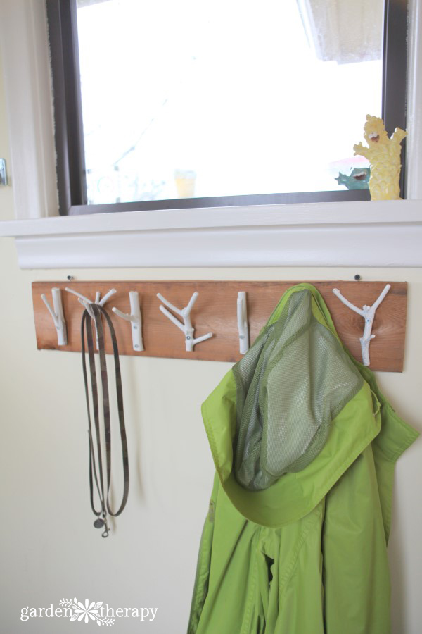 This inexpensive and easy weekend project shows you how to create a stylish branch coat rack with just some branches, paint, and a few tools.