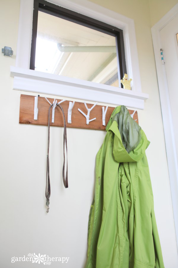 This inexpensive and easy weekend project shows you how to create a stylish branch coat rack with just some branches, paint, and a few tools.