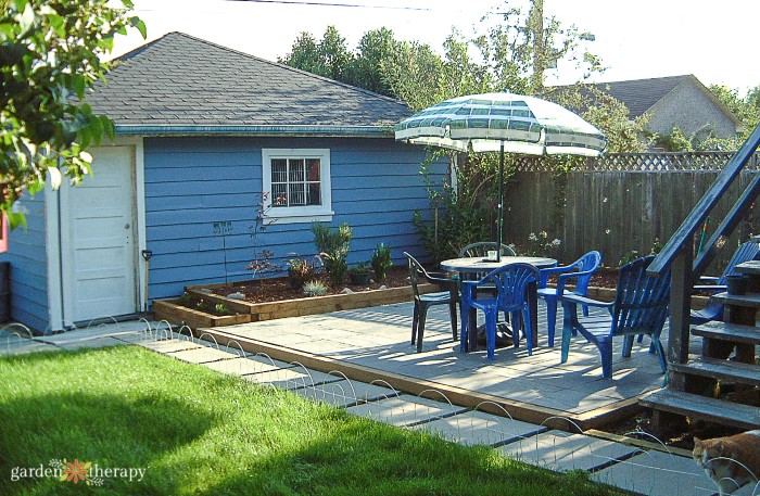 Blue home with a paved patio in the backyard