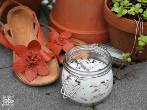 Herbal foot soak with dried flowers next to sandals