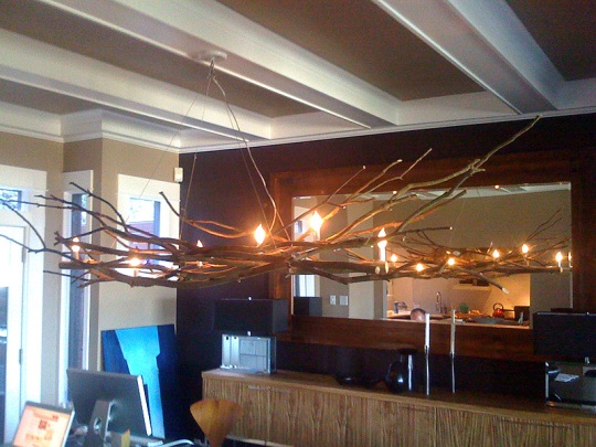 Homemade tree branch chandelier over a dining area