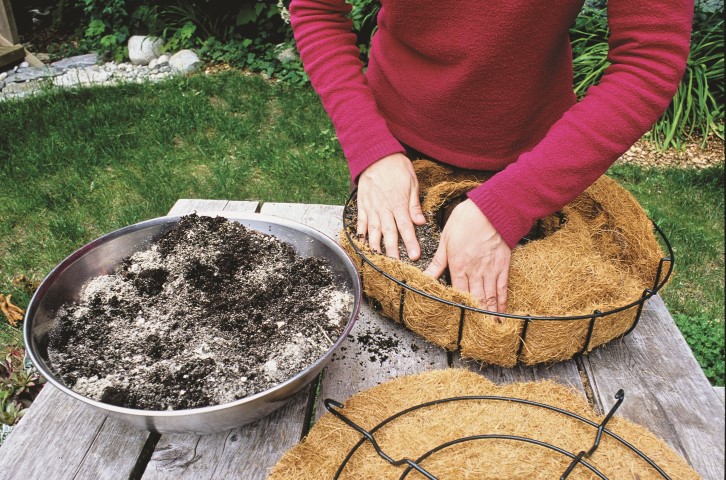 adding soil to a wreath form to make a planted wreath
