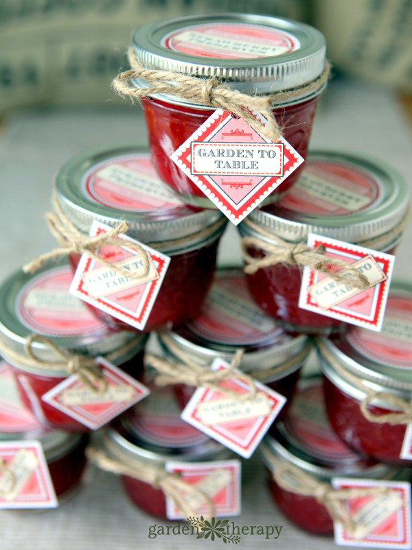 stack of homemade low sugar starwberry freezer jam with labels.