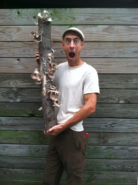 Michael Judd holding a shiitake mushroom log