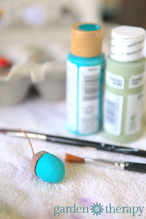 painting clay acorns from the DIY ornaments for the holidays tutorial