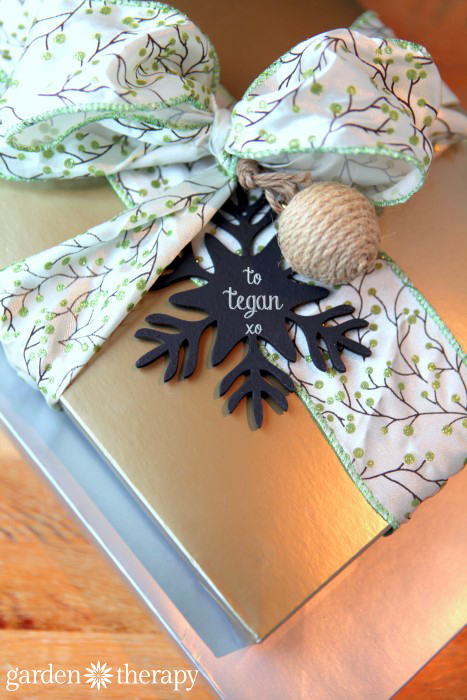 Gifts wrapped with chalkboad painted wood ornaments as gift tags