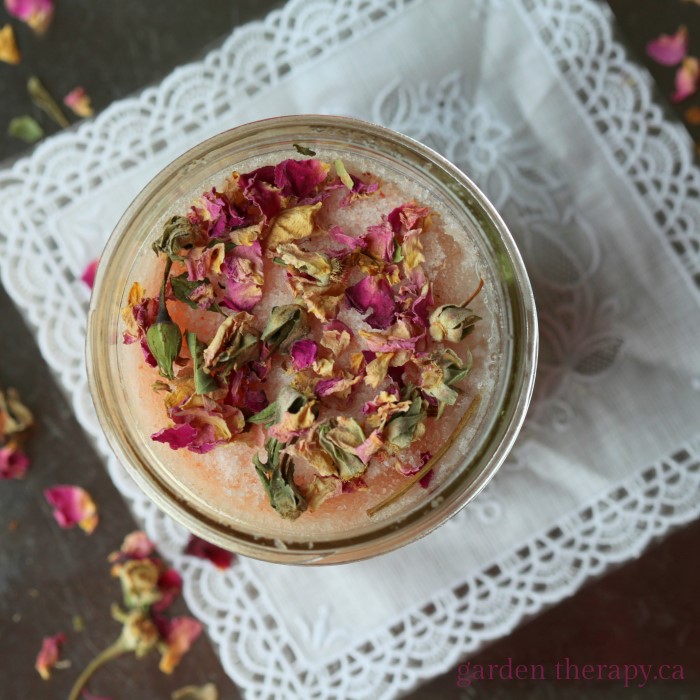 pink salt scrub in a mason jar topped with dried flowers