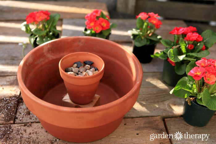 Make a gorgeous outdoor centerpiece with just a few annuals, terracotta pots, and a candle!