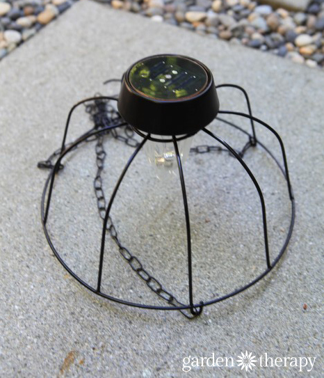 DIY Solar Light Chandelier sitting on a gray paver