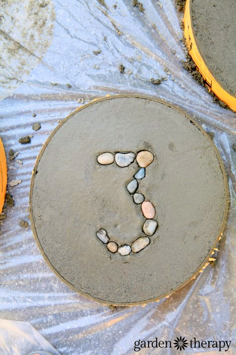 How to make concrete stepping stones for the garden with numbers set in rocks (5)