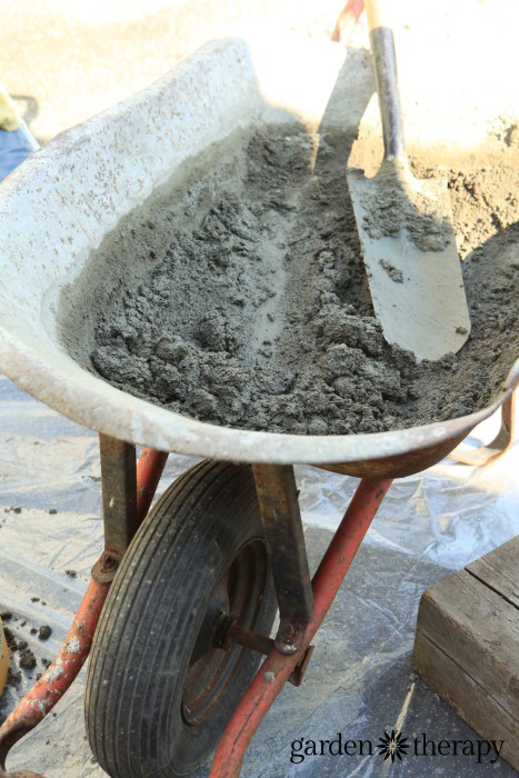 Mixing concrete in a wheelbarrow to make stepping stones