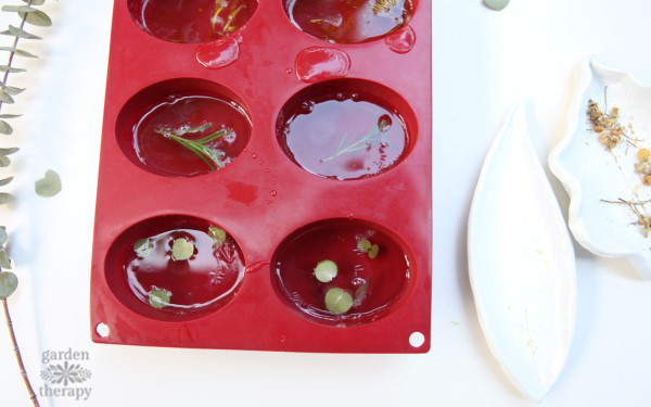 Oval soap mold filled with clear soap bars with botanicals inside