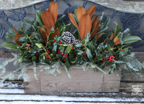 a festive holiday window box with a wood planter and some fresh Christmas greenery