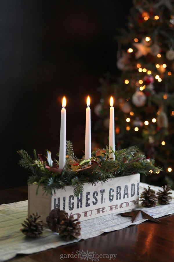 A rustic and natural Christmas candle centerpiece made out of Christmas greenery