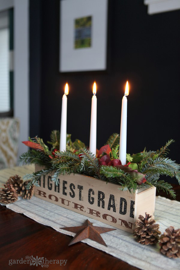 A rustic and natural Christmas candle centerpiece planter can be used as table decor, fireplace mantle, or even outdoors on the porch. See the DIY.