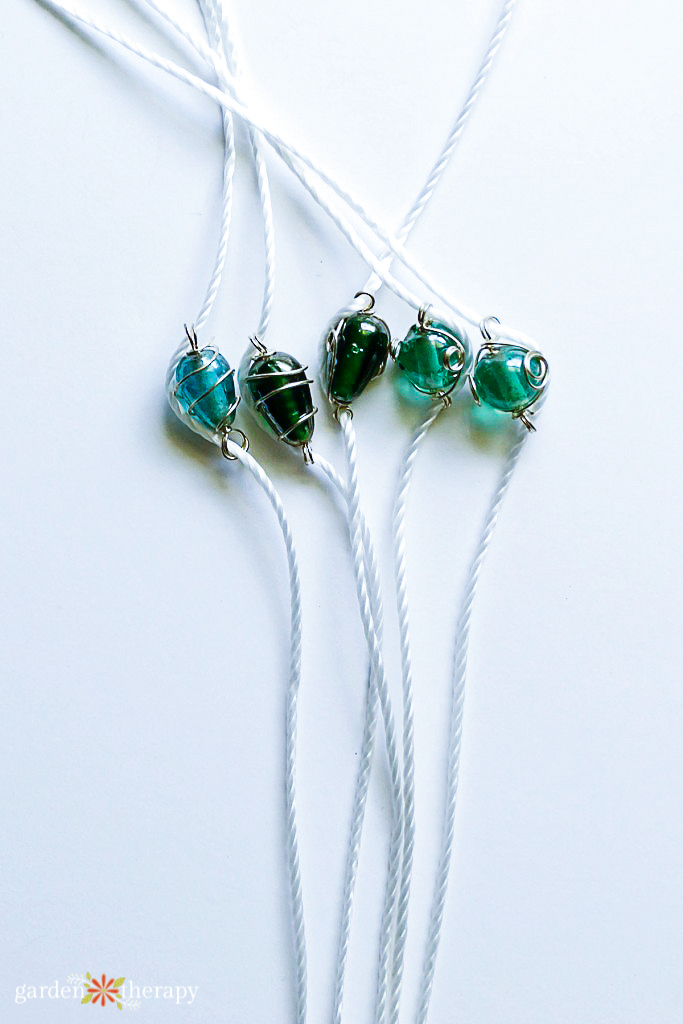 Beads being knotted into the strings for a butterfly feeder