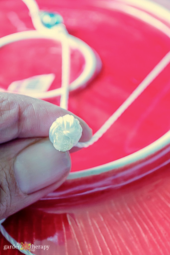 Woman showing a bead in a DIY feeder project