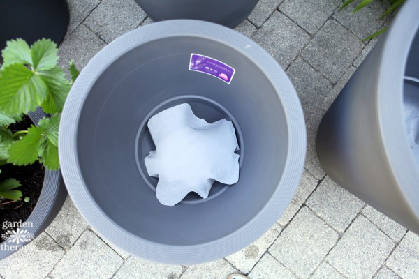 Line pots with landscape fabric