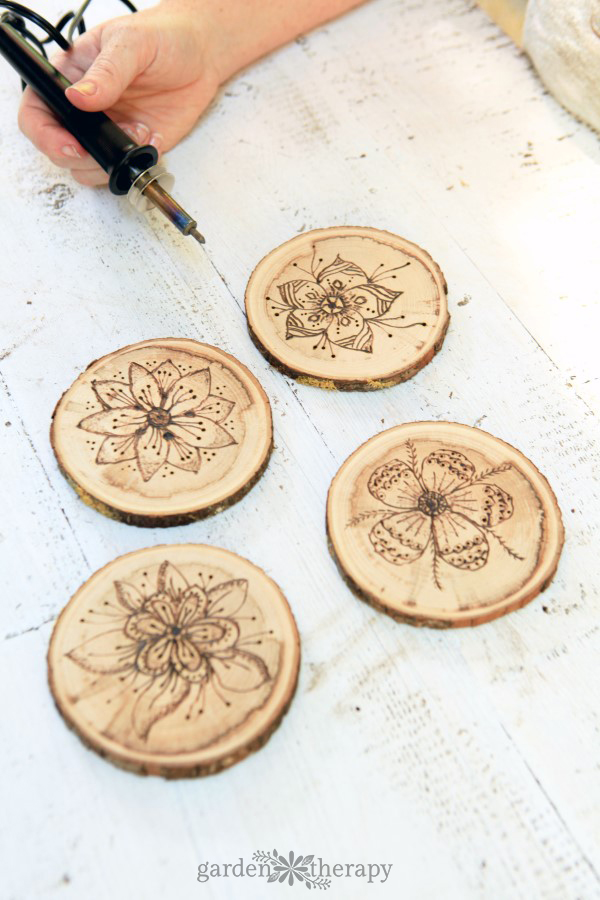 Close up of someone wood burning homemade coasters as a Christmas tree craft