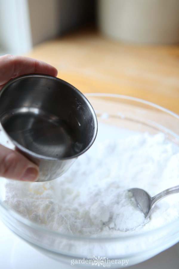 making a cleaning bombs recipe by adding citric acid to bowl