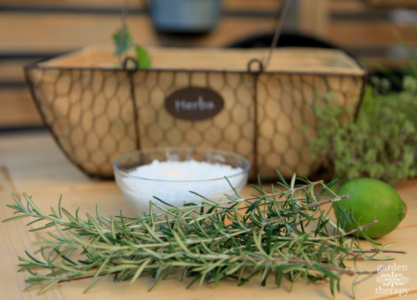 harvesting rosemary sprigs alongside a lime, bowl or salt, and basket