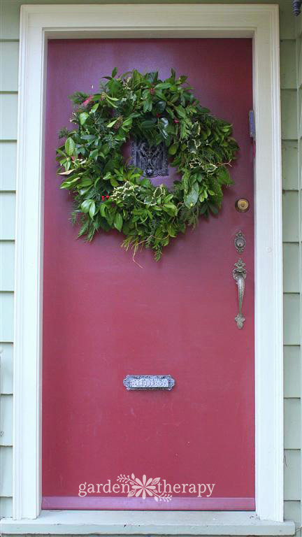 green diy wreath on a red door