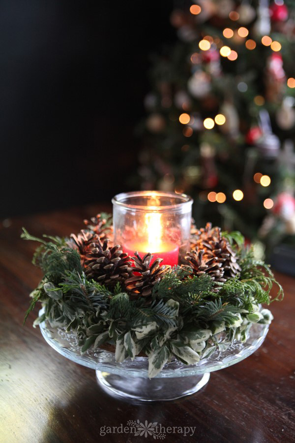 Christmas candle wreath featuring many different types of greenery