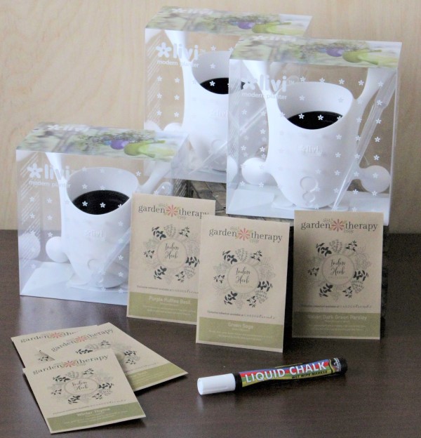 A liquid chalk pen, six seed packets, and three white plastic pots with suction feet.