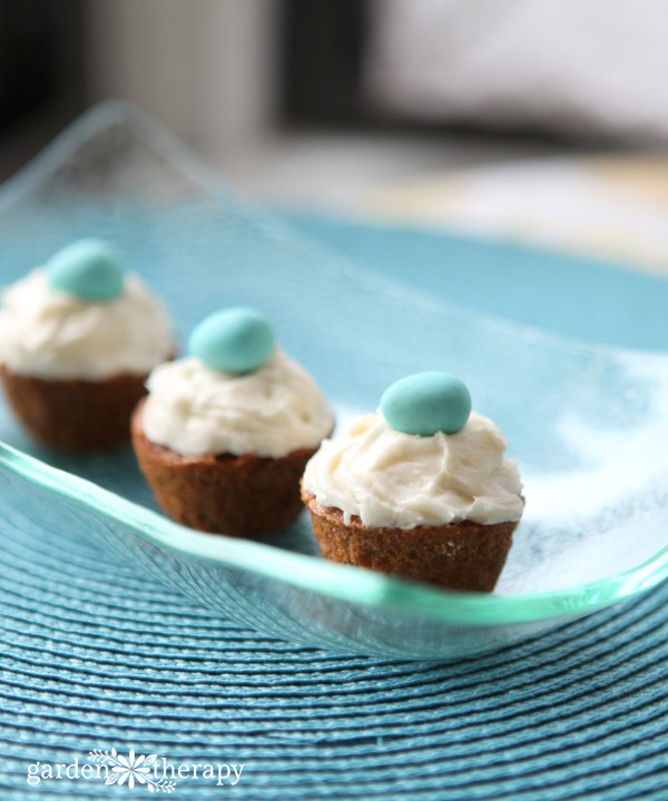 Mini whole wheat carrot cupcakes topped with cream cheese frosting and a chocolate egg