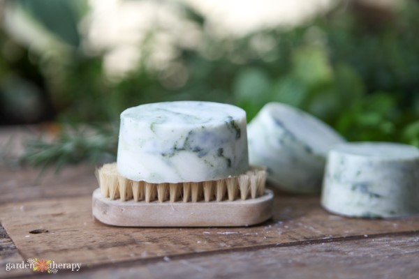 handmade soap bar resting on a nail brush