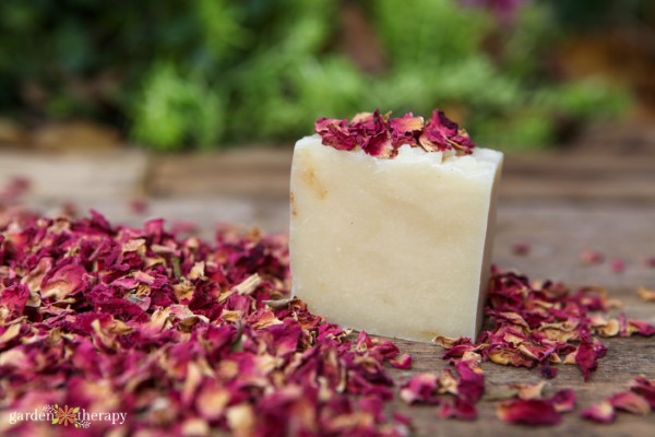 Chunk of natural plant based soap surrounded by dried rose petals