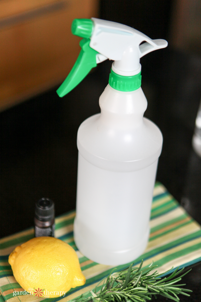 Spray bottle next to lemon and rosemary on a coutnertop