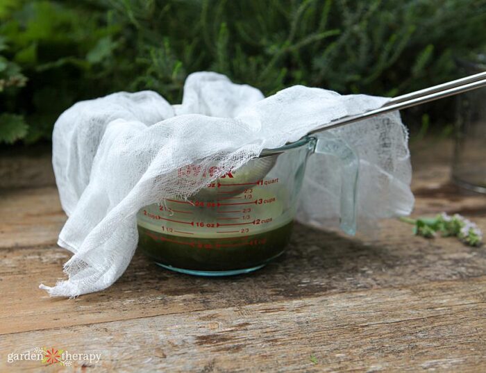 nut milk bag being used to squeeze out excess moisture from pest spray ingredients