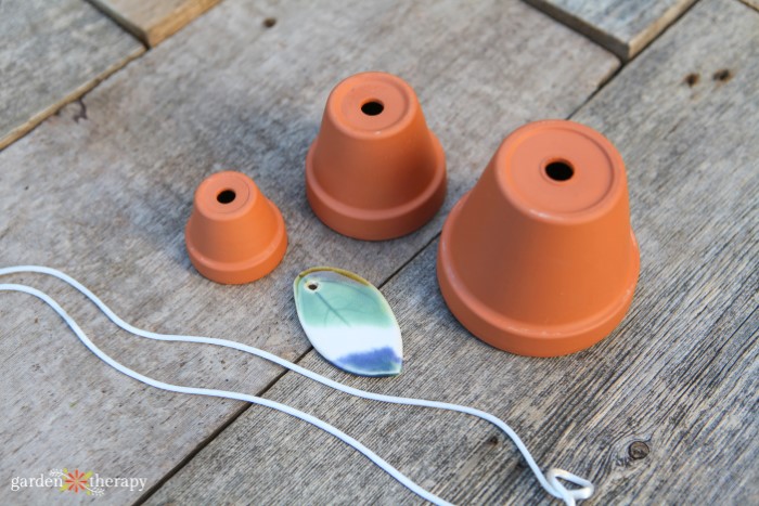 three terracotta pots, outdoor cord, and stone pendant