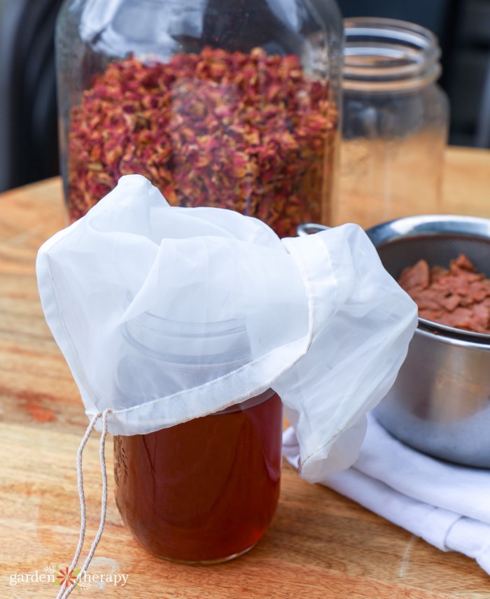 straining rose petals through nut bag