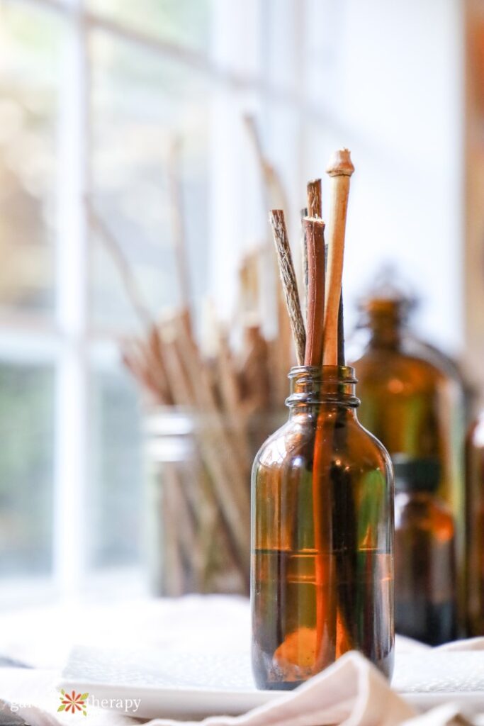 DIY reed diffuser in an amber jar in front of a window