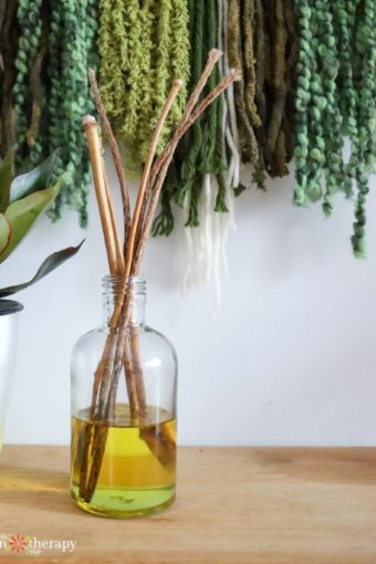 DIY reed diffuser in front of a textured art piece