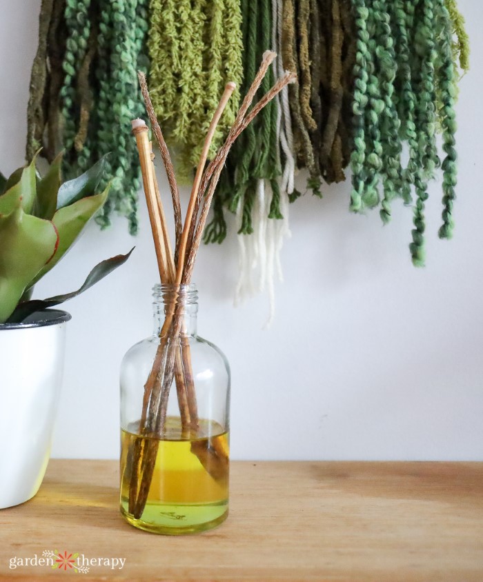 DIY reed diffuser in front of a textured art piece