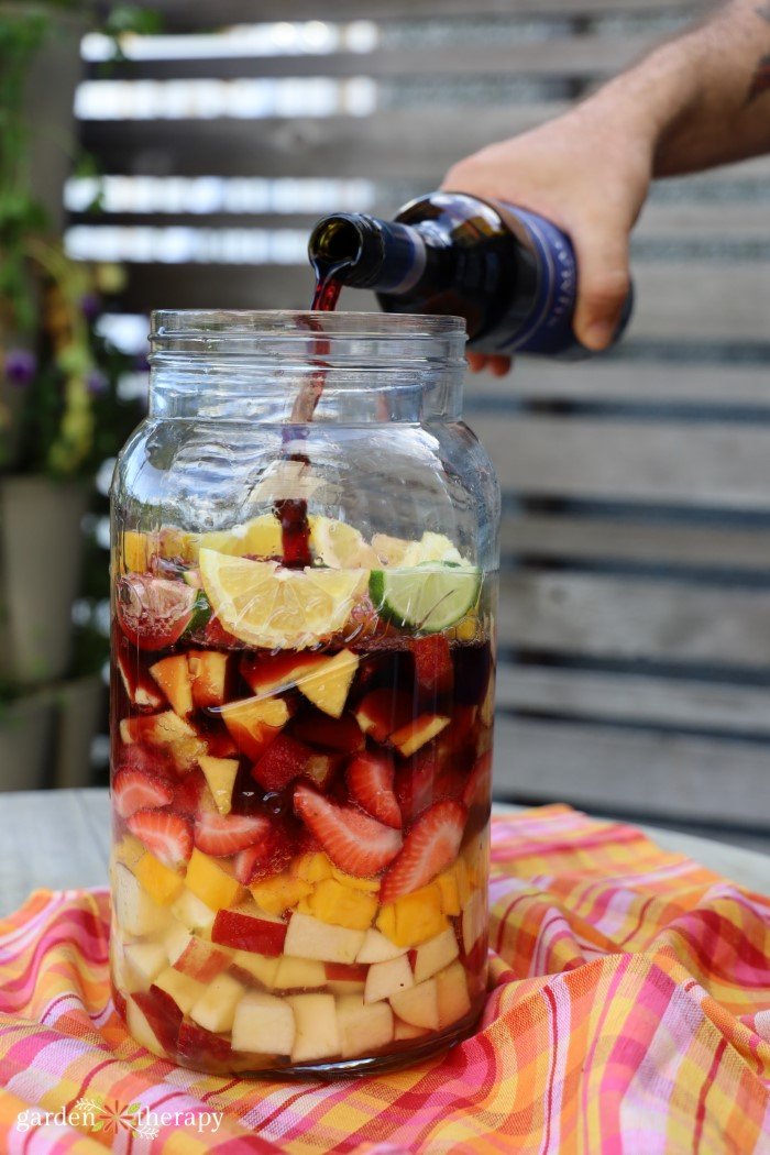 making sangria in a large glass jar