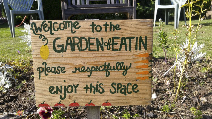 wooden sign reading welcome to the garden of eatin, please respectfully enjoy this space