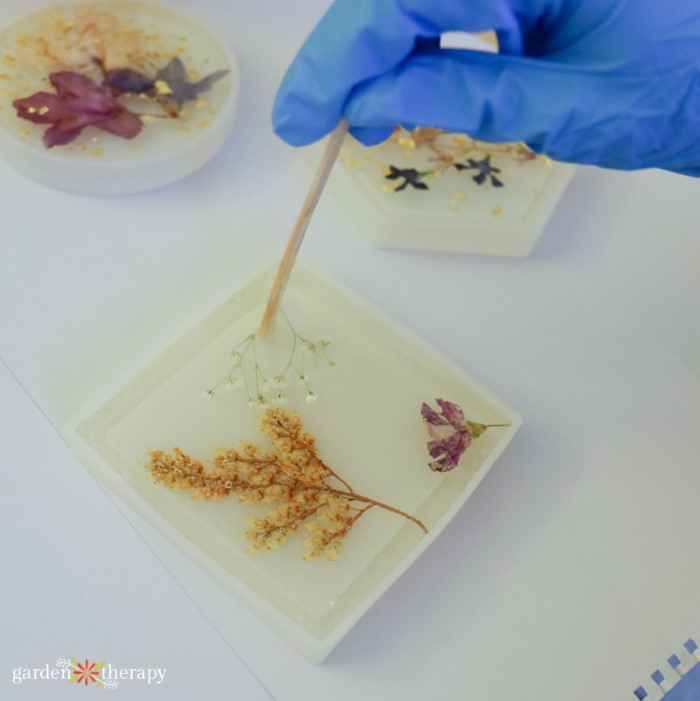 moving flowers in resin with popsicle stick