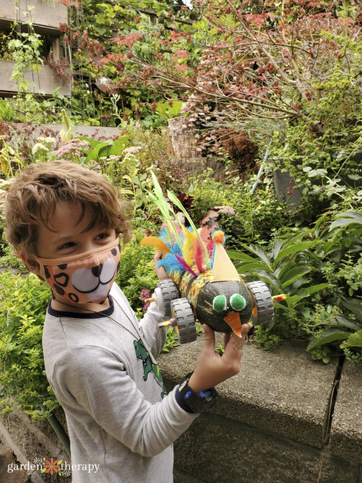 child holding a zucchini dressed as a racer