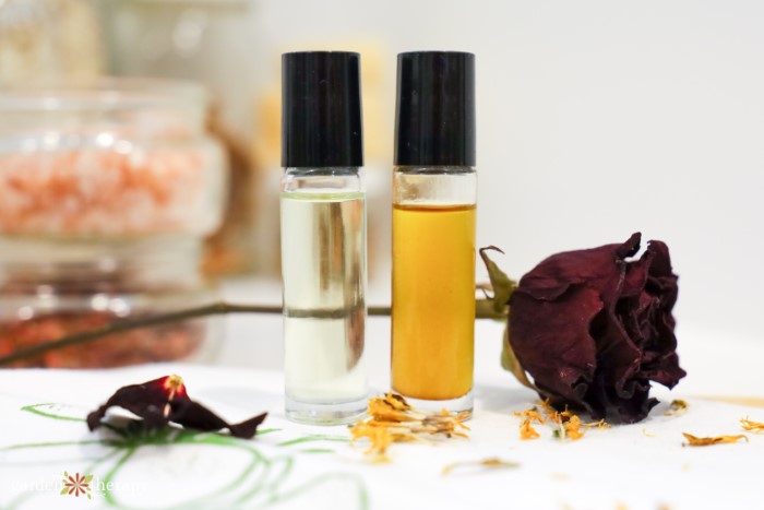 Natural perfume roller bottles next to dried flowers