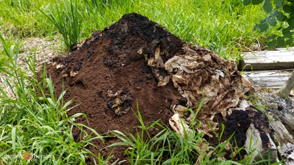 hromada kompostu s kávovou usadeninou navrchu