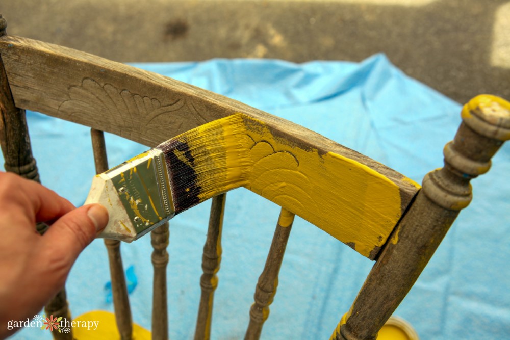 dipingere la sedia di supporto peonia gialla con un pennello